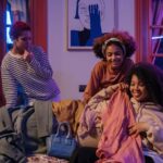 Three women having a joyful indoor gathering, enjoying fashion and friendship.